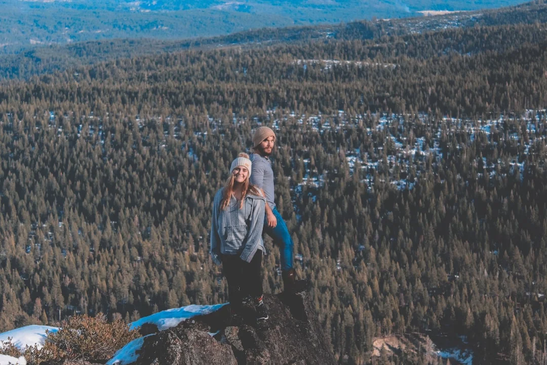 一對情侶在山頂擁抱，共同欣賞壯麗景色